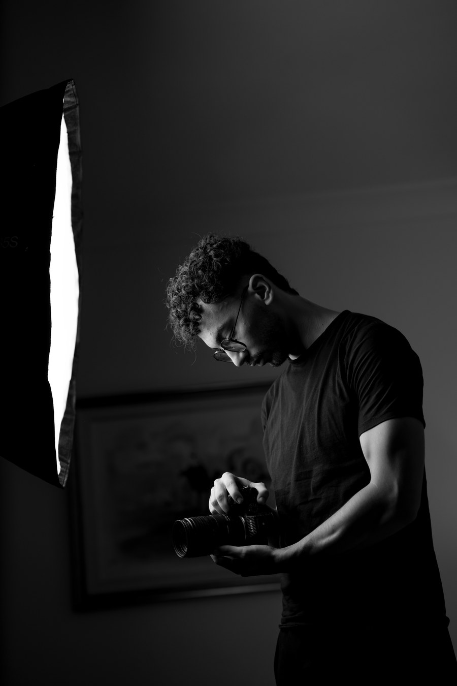 Daly Hadjtaieb reviewing a shot on camera beside a softbox